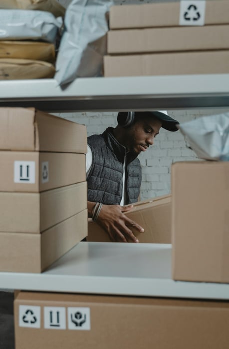 Warehouse worker picking a box off a shelf